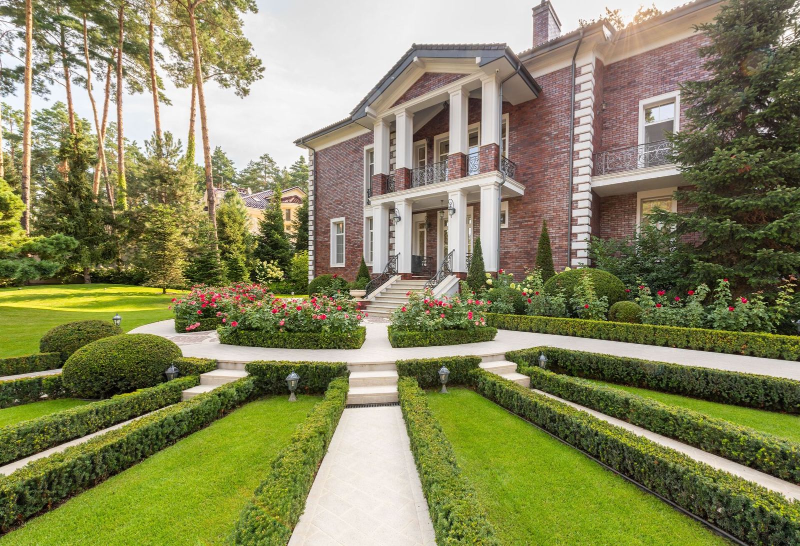 Clipped hedges framing neatly kept lawn panels and paths